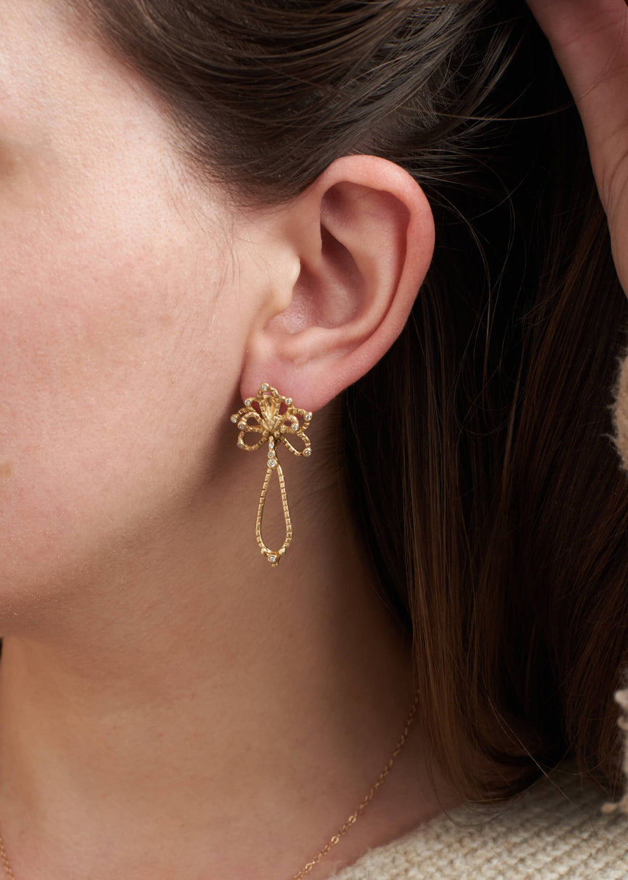Solid 14k gold diamond dangle Orchid earrings on model