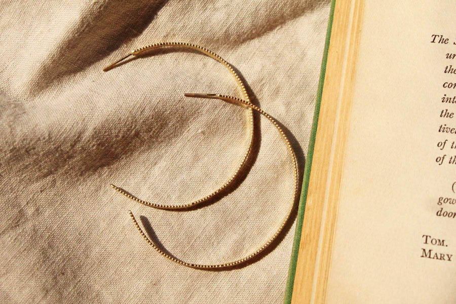 14k solid gold hoop earrings with beaded texture next to book, Eternal Hoops, ready to ship